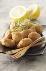 Closeup view of cod Beignets with lemon and rosemary — Stock Photo