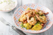 Plantain curry with prawns on plate  over wooden surface with fork — Stock Photo
