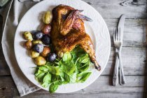 Half of grilled chicken with roast potatoes — Stock Photo