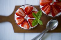 Vue rapprochée du dessus des desserts à la fraise en couches dans des verres — Photo de stock