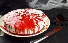 Gâteau d'Halloween avec éclaboussures de sang rouge vif — Photo de stock