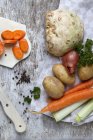 Ingredientes para estofado de verduras sobre superficie de madera con toalla - foto de stock