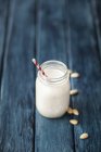 Миндальное молоко в стакане с соломой — стоковое фото