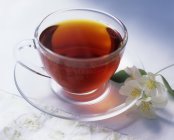 Cup of black tea with jasmine — Stock Photo