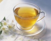 Tasse grüner Tee mit Jasminblüten — Stockfoto