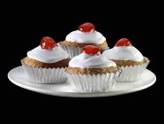 Cupcakes with cocktail cherries — Stock Photo