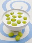 Closeup view of natural yogurt with green grapes — Stock Photo