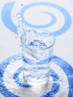 Água salpicando em um copo — Fotografia de Stock