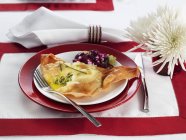 Con ripieno di zucchine su piastra rossa con forchetta sopra asciugamano con coltello — Foto stock