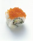 Closeup view of one reverse California roll on white surface — Stock Photo