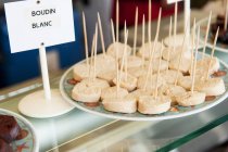 Vista de primer plano de Boudin blanc en rodajas con palillos en un puesto de mercado - foto de stock