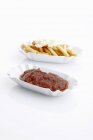 Curried sausage with chips and ketchup — Stock Photo
