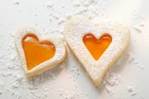Closeup view of sweet pastry hearts with apricot jam and icing sugar — Stock Photo