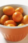 Kumquats en tazón de naranja - foto de stock