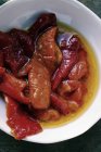 Маринованный красный перец с оливковым маслом в белой тарелке — стоковое фото