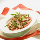 Carpaccio with rocket on plate — Stock Photo