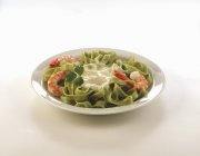 Green tagliatelle pasta with shrimps — Stock Photo