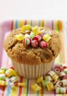Muffin with candies on colorful tray — Stock Photo