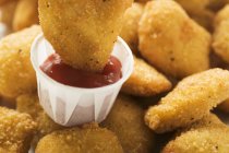Chicken Nugget in Ketchup tauchen — Stockfoto