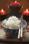 Bowl of rice with chopsticks — Stock Photo
