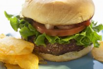 Гамбургер с помидорами и чипсами — стоковое фото