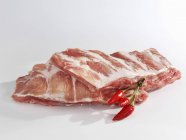 Costillas de cerdo crudas con chiles - foto de stock