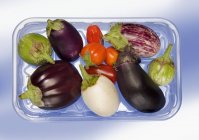 Fresh aubergines in plastic tray — Stock Photo