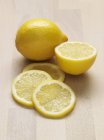 Limón entero con mitad y rodajas - foto de stock