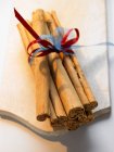 Cinnamon sticks on chopping board — Stock Photo