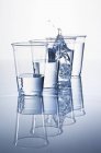 Крупный план пластиковых стаканов с водой и брызгами в одном — стоковое фото