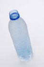 Vista da vicino della bottiglia d'acqua aperta sulla superficie bianca — Foto stock
