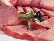 Sliced salami and olives — Stock Photo