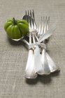 Tomato with tied forks and spoons — Stock Photo