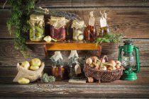Various preserved vegetables and mushrooms on a wooden shelf — Stock Photo