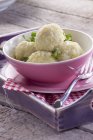 Potato dumplings in a bowl over tray with fork — Stock Photo