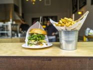 Hamburger sur plaque et chips — Photo de stock