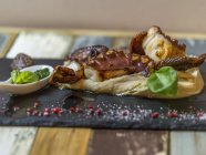 Nahaufnahme von Krakenstücken auf Polenta mit Basilikum-Pesto — Stockfoto