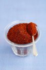 Closeup view of spicy Korean chilli powder in a glass bowl and on a spoon — Stock Photo