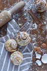 Closeup view of cinnamon rolls with sugar icing on towel — Stock Photo