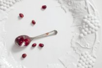 Pomegranate seeds on spoon — Stock Photo