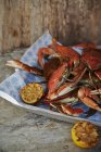 Cooked crabs with lemon halves on a serving platter — Stock Photo