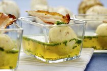 Zuppa con gnocchi di pancetta e semola in piccole ciotole di vetro — Foto stock