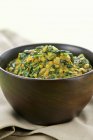 Stufato di spinaci e lenticchie con spezie orientali in ciotola nera — Foto stock