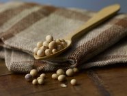 Soya beans on wooden spoon — Stock Photo