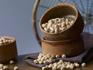 Chickpeas in an earthenware bowl  over wooden surface — Stock Photo