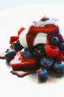Вид вблизи свежих ягод со сливками и сиропом — стоковое фото
