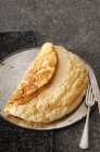 Sponge omelette on a round baking tray with cutlery on a grey stone surface — Stock Photo
