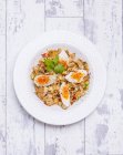 Vista superior de Kedgeree picante con huevos en tazón blanco - foto de stock