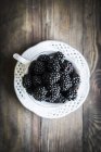 Fresh blackberries in teacup — Stock Photo