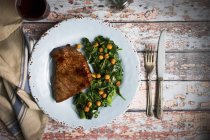 Beef steak with chickpea and spinach medley — Stock Photo